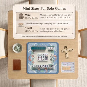 May include: A wooden table displays a mini Mahjong set with a blue mat featuring koi fish. The set includes tiles, a small brown book, and a bowl of green spheres. Text on the table indicates mini and small sizes, 40 cm and 50 cm.