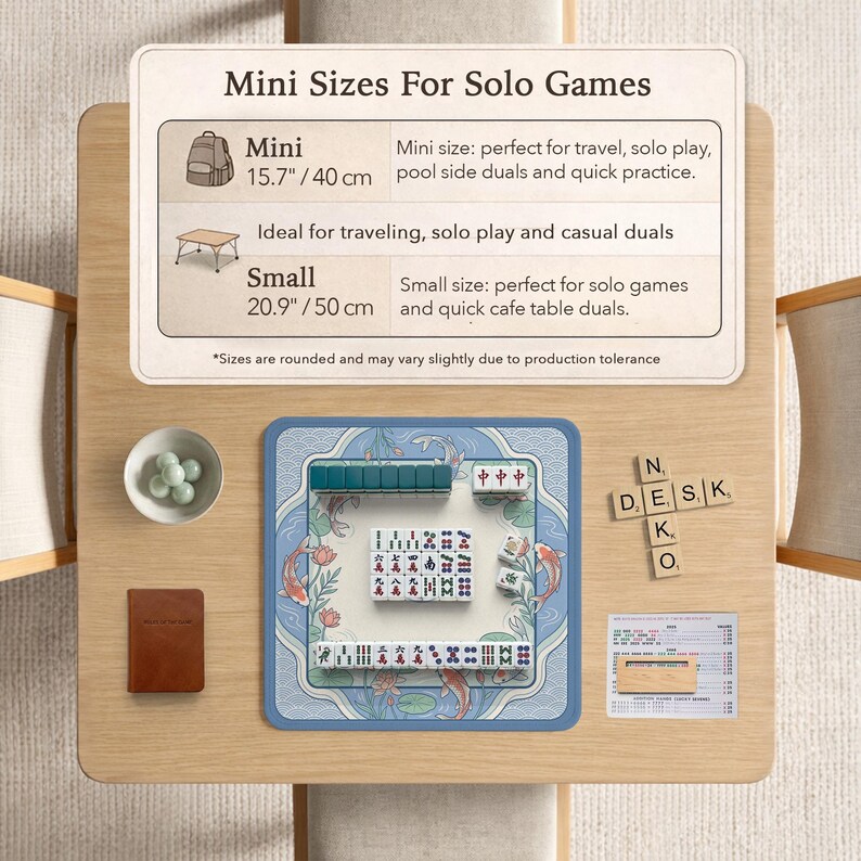May include: A wooden table displays a mini Mahjong set with a blue mat featuring koi fish. The set includes tiles, a small brown book, and a bowl of green spheres. Text on the table indicates mini and small sizes, 40 cm and 50 cm.