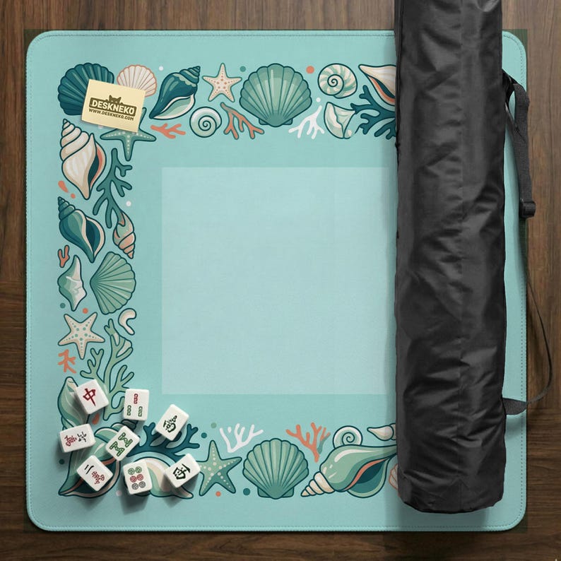 May include: A light blue play mat with a sea life border featuring seashells, starfish, and coral. The mat includes a set of Mahjong tiles and a black carrying case. The Deskneko logo is visible in the corner.