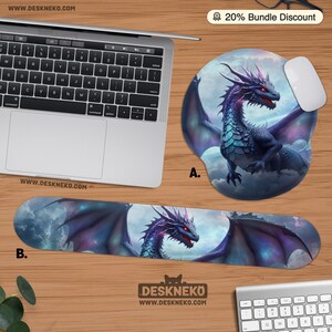 May include: A computer mouse pad and wrist rest featuring a fantasy dragon design. The dragon is depicted with purple, blue, and red hues against a cloudy sky background. The mouse pad is round, and the wrist rest is rectangular.