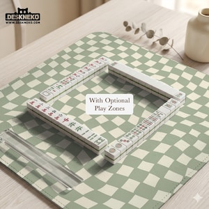 Könnte beinhalten: Ein Mahjong-Set mit weißen Spielsteinen mit roten, grünen und schwarzen Symbolen, angeordnet auf einer grün-weiß karierten Matte. Der Text "With Optional Play Zones" ist sichtbar. Das Logo von DESKNEKO befindet sich in der oberen linken Ecke.