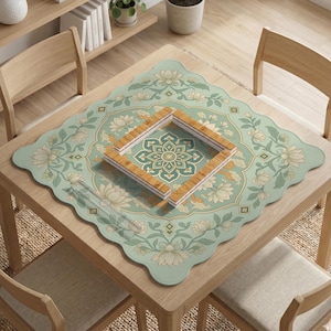 May include: A square, scalloped-edge table mat featuring a light green background with a repeating cream-colored lotus flower and vine pattern. In the center, a square frame is constructed from four rectangular, light-brown bamboo tiles.