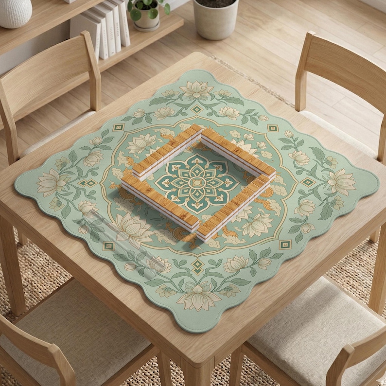 May include: A square, scalloped-edge table mat featuring a light green background with a repeating cream-colored lotus flower and vine pattern. In the center, a square frame is constructed from four rectangular, light-brown bamboo tiles.