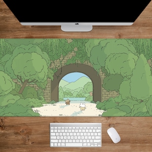 May include: A rectangular mouse pad featuring a whimsical illustration of a tunnel leading to a scenic landscape. The design includes lush green foliage, a stone archway, and cartoon characters. The pad is designed to sit under a keyboard and mouse.