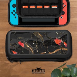 May include: Black Nintendo Switch carrying case with a koi fish design. The case features a black zipper and a black interior with storage for game cartridges. The design includes gold accents and red koi fish on a black background. The brand name "DESKNEKO" is visible.