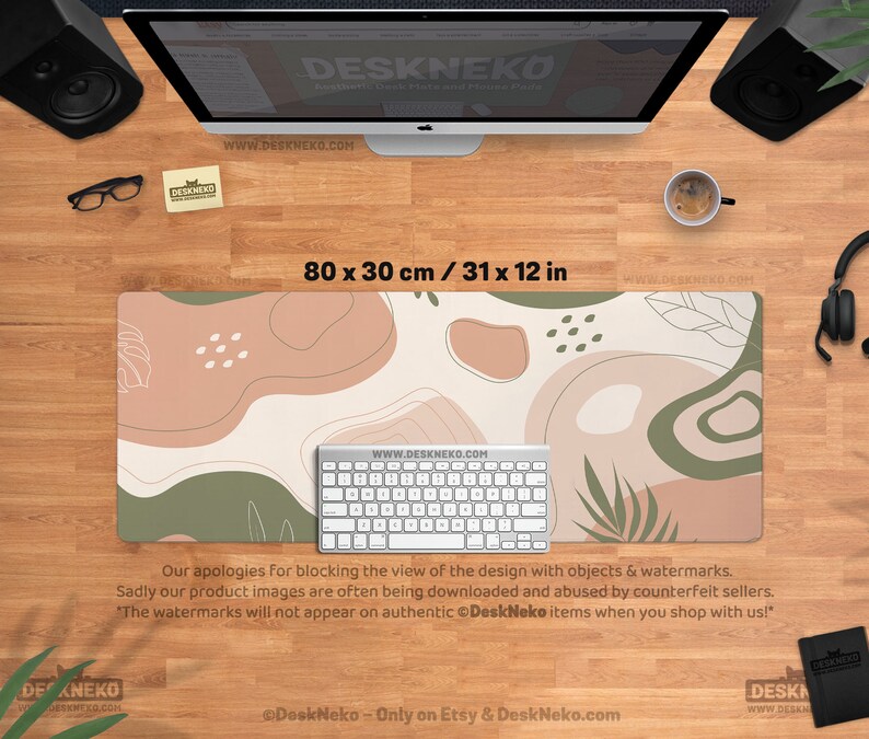 Puede incluir: Alfombrilla de escritorio rectangular, de 80 x 30 cm, con un dise&ntilde;o abstracto en tonos beige, marr&oacute;n y verde. Un teclado blanco est&aacute; encima. El texto "DeskNeko" y una direcci&oacute;n web son visibles.