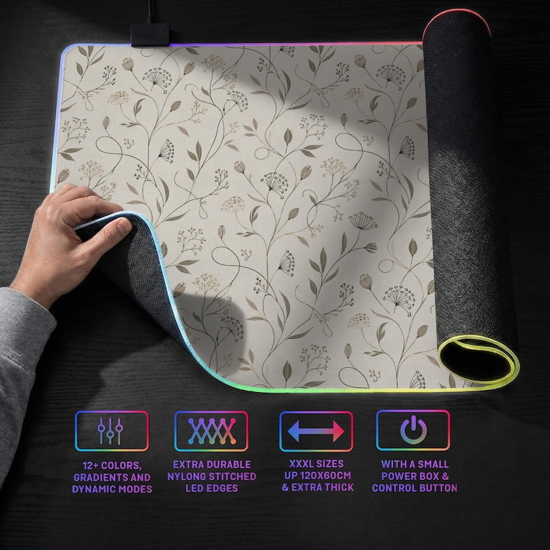 Pu&ograve; includere: Un grande tappetino per mouse rettangolare con superficie beige e un delicato motivo botanico a linee marroni. I bordi sono dotati di luci LED e il testo indica 12+ colori, bordi in nylon cuciti, dimensioni 120x60cm e una scatola di alimentazione.