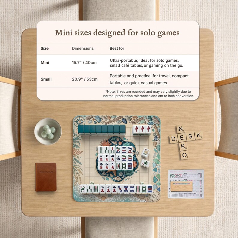 May include: A mini mahjong set on a wooden table. The set includes tiles, dice, and a small brown book. The text on the table reads "Mini sizes designed for solo games". The mini size is 15.7 inches / 40cm.
