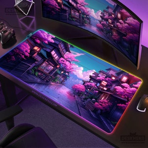May include: A rectangular gaming mouse mat featuring a Japanese street scene with cherry blossom trees. The mat has a colourful LED edge and the website address www.deskneko.com printed on it.