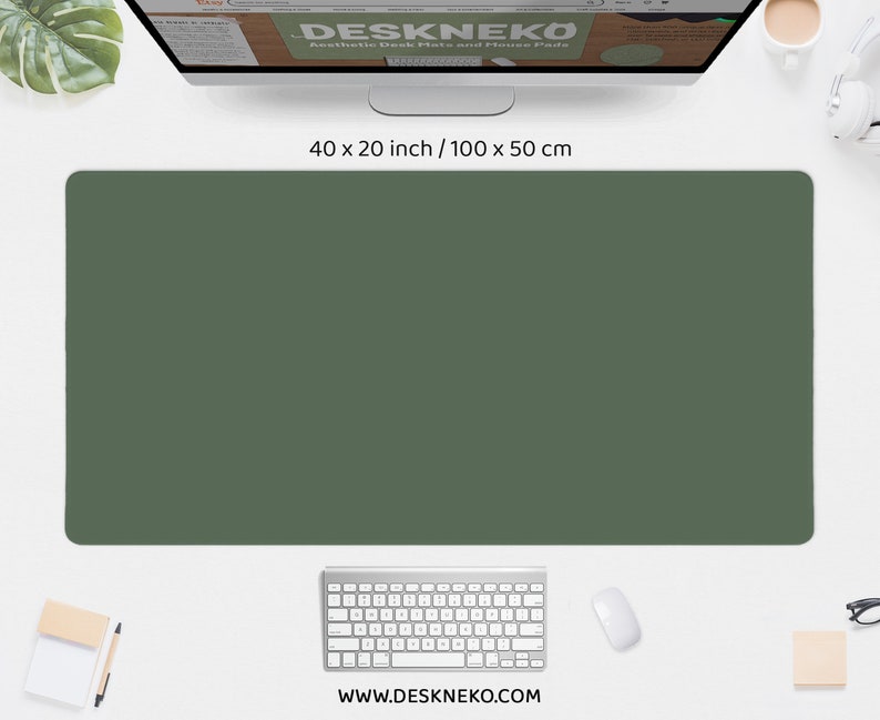 May include: A solid olive green desk mat, 40 x 20 inches, with rounded corners. A computer keyboard, mouse, and monitor are visible. The website address www.deskneko.com is printed at the bottom of the mat.