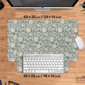 Puede incluir: Dos alfombrillas de escritorio con estampado floral, 60 x 35 cm y 45 x 35 cm, con teclado y rat&oacute;n sobre un escritorio de madera. Las alfombrillas tienen un fondo gris verdoso con dise&ntilde;os florales blancos. La web www.deskneko.com es visible.