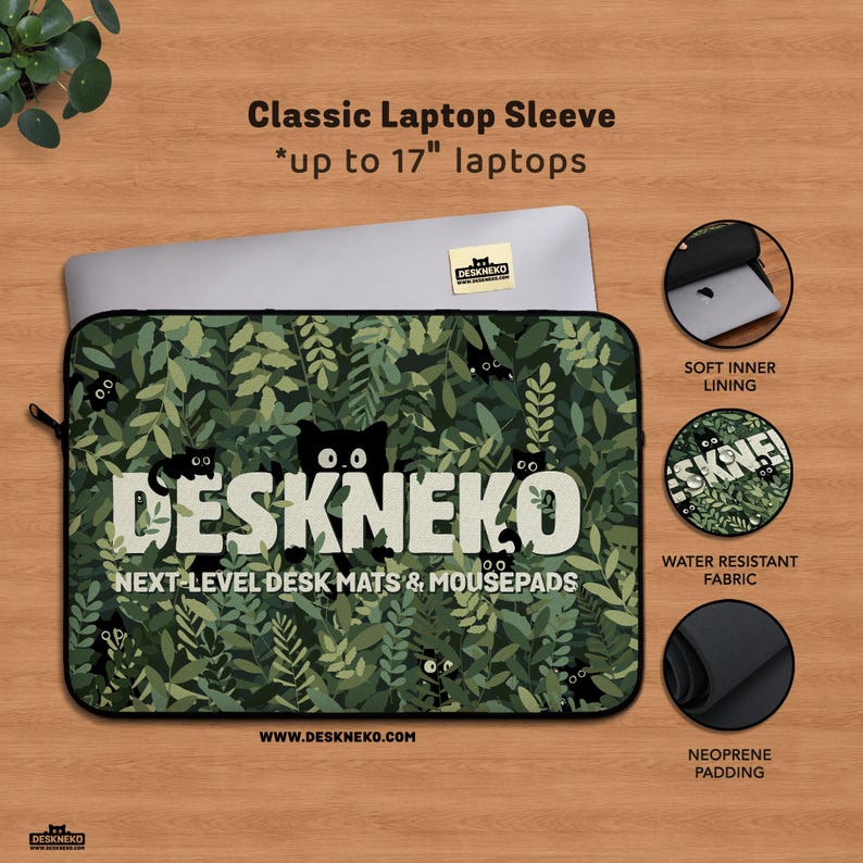Product image of a DeskNeko classic laptop sleeve displayed on a wooden desk. The sleeve features a green leafy botanical pattern. A macbook pro laptop is partially inserted into the sleeve, showing a snug fit suitable for laptops from 12 inch, 13 inch, 14 inch and 15 inch up to 17 inches. The sleeve has black piping and a zipper closure. Three icons highlight key features: a soft inner lining for scratch protection, water-resistant outer fabric, and thick neoprene padding for shock absorption.