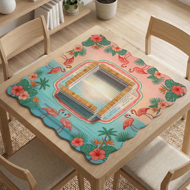 May include: A square game mat with scalloped edges featuring a tropical pattern of pink flamingos, green palm leaves, and red hibiscus flowers. The center displays a square wooden tile rack with text including Play Right, Walls Left, and Play Left.