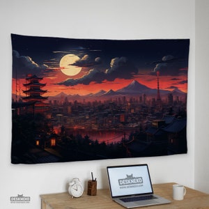 May include: A tapestry depicting a Japanese cityscape at dusk. The artwork features a large full moon, a pagoda, and a city skyline under a vibrant orange and red sky. The tapestry is hanging on a white wall.