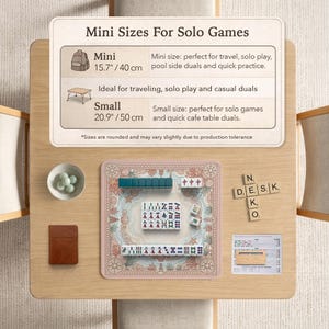 May include: A tabletop setup featuring a Mahjong set with green and white tiles, a small brown notebook, and a bowl of green spheres. The set is on a pink mat with a nautical design. The text on the sign says "Mini Sizes For Solo Games".