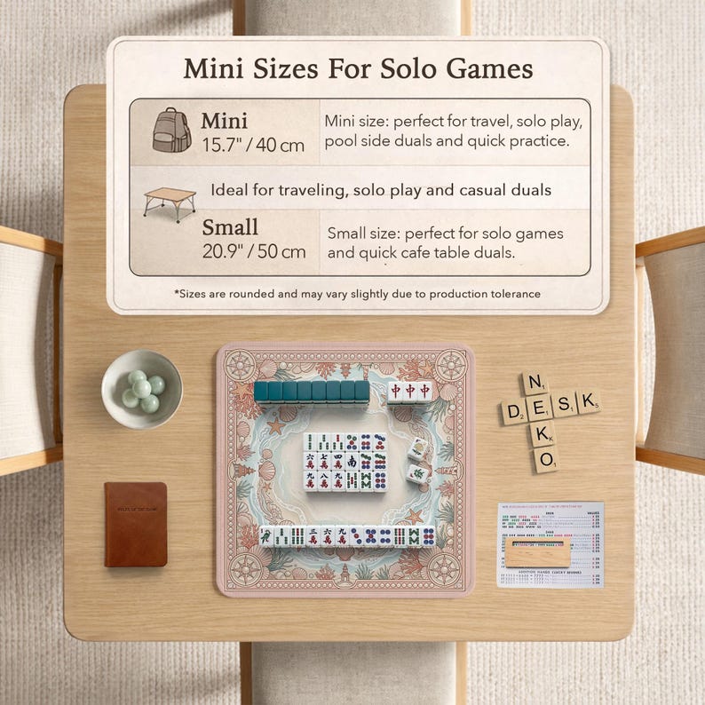 May include: A tabletop setup featuring a Mahjong set with green and white tiles, a small brown notebook, and a bowl of green spheres. The set is on a pink mat with a nautical design. The text on the sign says "Mini Sizes For Solo Games".