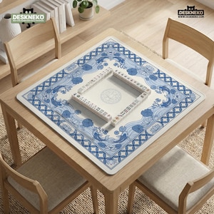 May include: A square mahjong table mat with a blue and white koi fish design. The mat is on a wooden table with a mahjong set in the center. The mat has a floral border and the text "DESKNEKO" in the top corners.