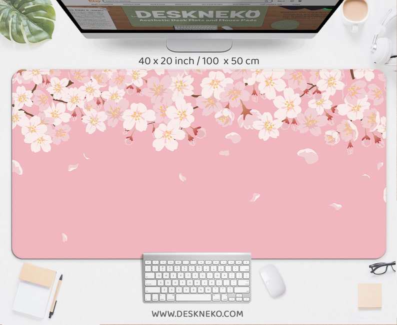 May include: Aesthetic desk mat and mouse pad with a pink background and a floral cherry blossom design. The mat measures 40 x 20 inches (100 x 50 cm). The website address www.deskneko.com is printed at the bottom.