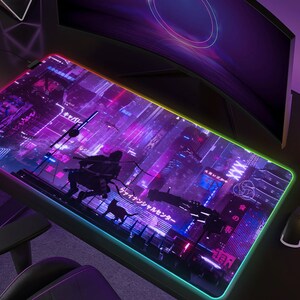 May include: Large rectangular gaming mouse pad with a vibrant neon cityscape design in purple, blue, and pink. The pad features a silhouette of a figure and a cat, with Japanese text. The edges are illuminated with a rainbow LED light.