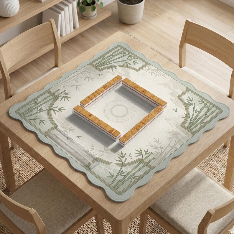 May include: A square mahjong mat with scalloped edges featuring a light green and white bamboo pattern. In the center, four rows of light brown wooden mahjong tiles are arranged in a square formation on a white surface with a circular design.