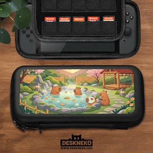 Puede incluir: Funda de transporte negra para Nintendo Switch con una colorida ilustración de carpinchos relajándose en una fuente termal. La funda está abierta, revelando la consola Switch y los cartuchos de juego. La funda está sobre una superficie de madera.