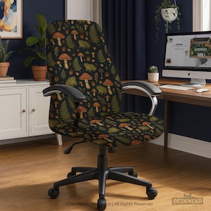 Puede incluir: Una silla de oficina con base y reposabrazos negros. El asiento y el respaldo de la silla están cubiertos con una tela oscura con un patrón repetido de setas, helechos, llaves y ranas en tonos naranja, verde y marrón.