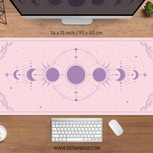 May include: A rectangular pink desk mat, 36 x 15 inches, featuring a celestial design with moons, suns, and stars in a lavender color. The mat has a decorative border and the text "WWW.DESKNEKO.COM" at the bottom.