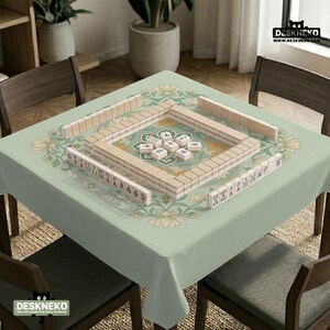 May include: A square table covered with a light green tablecloth featuring a floral pattern, set up for a game of mahjong. The table surface displays rows of white mahjong tiles arranged in a square formation, with additional tiles placed in the center.