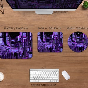 K&ouml;nnte beinhalten: Ein Holztisch zeigt einen Computermonitor, eine Tastatur und eine Maus sowie drei Mauspads mit einem lila-schwarzen Stadtlandschaftsdesign. Die Mauspads sind rechteckig und kreisf&ouml;rmig und messen 25x30 cm, 20x25 cm und 20x20 cm. Der Text "JAPAN" ist sichtbar.