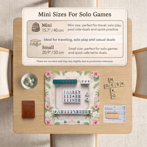 May include: A Mahjong set on a floral play mat with pink hibiscus and palm leaves. Includes tiles, a small bowl with green marbles, a brown notebook, and a wooden tile rack. Text reads: Mini Sizes For Solo Games, Mini 15.7 inches, Small 20.9 inches.