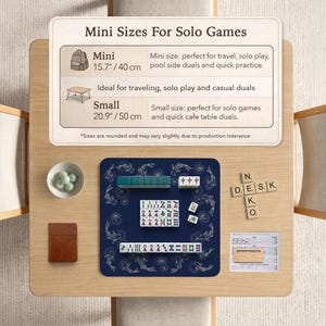 Puede incluir: Una mesa de madera exhibe un mini juego de Mahjong sobre una alfombra azul marino con dise&ntilde;os de peces. El juego incluye fichas, dados y un peque&ntilde;o cuaderno marr&oacute;n. El texto en la mesa dice "Mini Sizes For Solo Games".