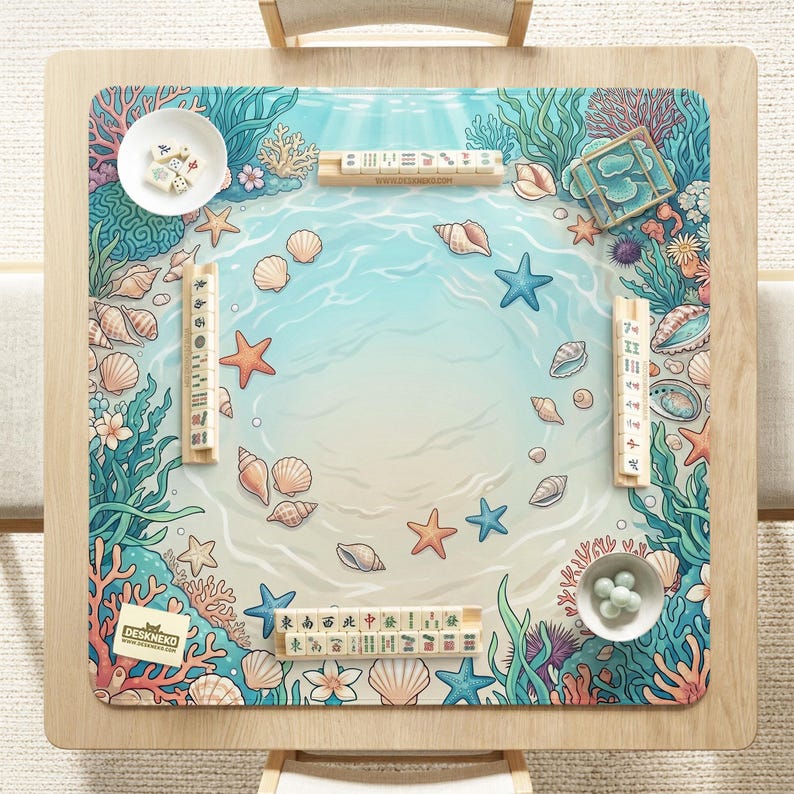 May include: A wooden mahjong table with a marine-themed design. The table features a light blue ocean scene with starfish, seashells, and coral. Includes mahjong tiles, dice, and other game pieces. The brand name "DESKNEKO" is visible.