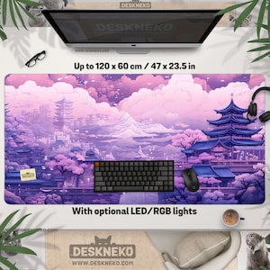 May include: A large desk mat with a Japanese-inspired landscape design in shades of purple and pink. The mat measures up to 120 x 60 cm and features a pagoda, mountains, and cherry blossom trees. The text "DESKNEKO" is visible.