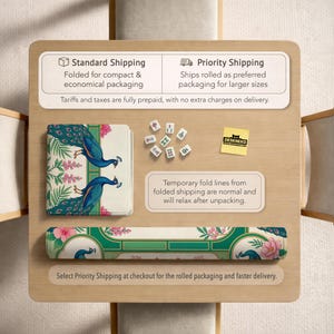 May include: A rectangular mat featuring a peacock and floral pattern in teal, green, and pink. The set includes a folded mat, a rolled mat, and several small white mahjong tiles. A yellow square note with the text DESKNEKO is visible on the surface.