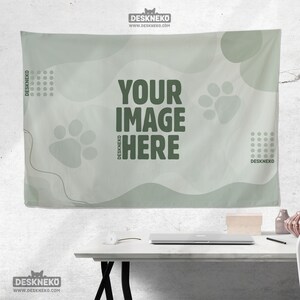 Peut inclure: Une tapisserie murale vert clair avec le texte "YOUR IMAGE HERE" en vert fonc&eacute;. La tapisserie pr&eacute;sente des empreintes de pattes et des formes abstraites. La marque "DESKNEKO" est imprim&eacute;e sur la tapisserie.
