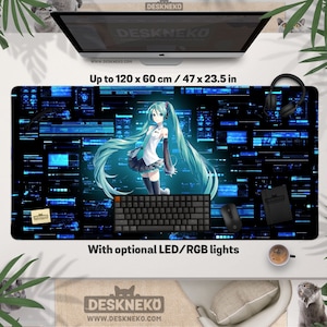 Op de afbeelding: Grote zwarte bureaumat met een anime-personage Hatsune Miku met lang turquoise haar, tegen een blauwe en zwarte digitale achtergrond. De mat meet tot 120 x 60 cm en bevat de tekst "DESKNEKO" en "With optional LED/RGB lights".