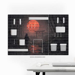 May include: Black pegboard organizer with white accessories and a Japanese-inspired graphic. The graphic features a red sun, a samurai, and a torii gate. Includes two small bins, a shelf, and hooks. The website address www.deskneko.com is visible.
