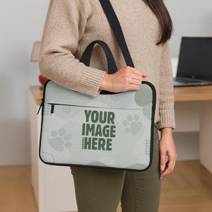 May include: A light green laptop bag with a black handle and shoulder strap. The bag features a design of paw prints and circles, with the text "YOUR IMAGE HERE" in dark green.