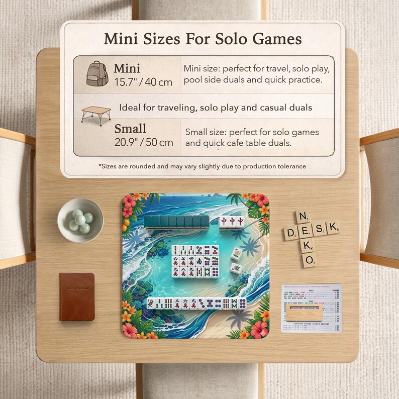 May include: A Mahjong set on a tropical beach-themed playmat with a printed informational sign titled Mini Sizes For Solo Games, listing dimensions of 15.7 inches and 20.9 inches, alongside a small bowl of marbles, a brown notebook, and wooden letter tiles.