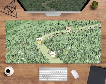 May include: A rectangular desk mat featuring a whimsical illustration of a path winding through a field of tall green grass and wildflowers. Cartoon characters in yellow dresses are walking along the path. A computer monitor, keyboard, and mouse are visible.