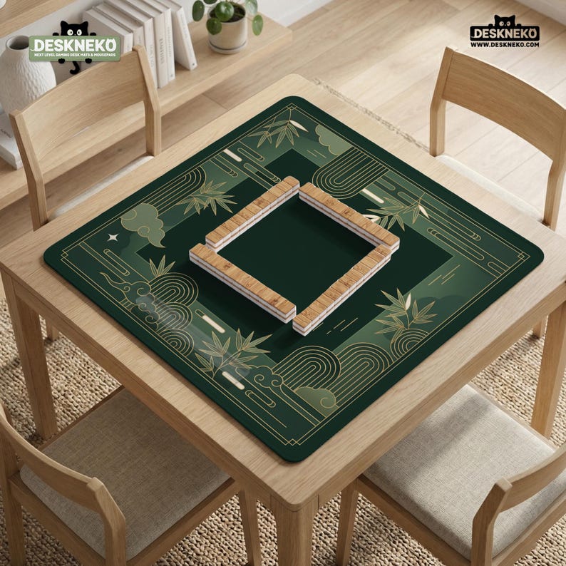 Pode incluir: Uma mesa quadrada de madeira com um tapete verde e dourado estampado, com desenhos de bambu e nuvens. O tapete tem um recorte quadrado com pe&ccedil;as de jogo de madeira no interior. A mesa &eacute; rodeada por quatro cadeiras de madeira. O texto "DESKNEKO" &eacute; vis&iacute;vel.
