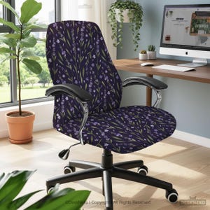 Puede incluir: Una silla de oficina con un estampado floral morado oscuro. El diseño presenta flores de color lavanda y tallos verdes sobre un fondo morado oscuro. La silla tiene reposabrazos negros y una base negra con ruedas. La silla está en un entorno de oficina en casa.