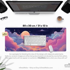 May include: A large desk mat with a dreamy night sky design, featuring a full moon, stars, and colorful clouds in shades of pink, purple, and blue. The mat measures 31 x 12 inches and has a keyboard and mouse on top.