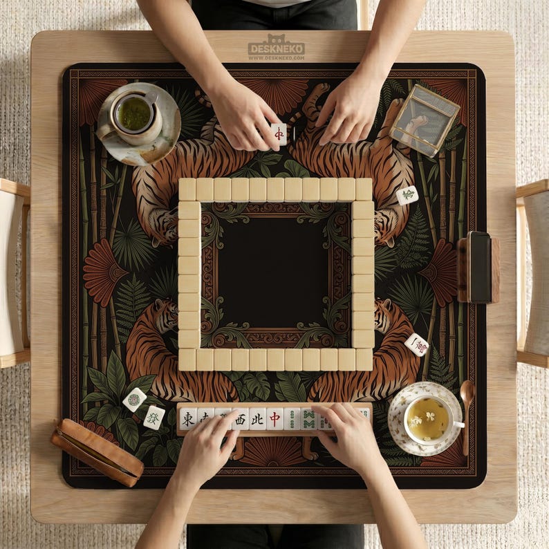May include: A wooden Mahjong game table with a decorative mat featuring tigers and bamboo. The game is in progress, with tiles and tea cups visible. The table has the text "DESKNEKO" on the top.