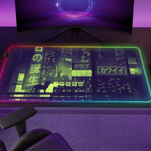 May include: Rectangular gaming mouse pad with a neon-lit edge. The pad features a cityscape design with Japanese text and a silhouette of a cat. The pad is on a black desk with a computer monitor and gaming accessories.