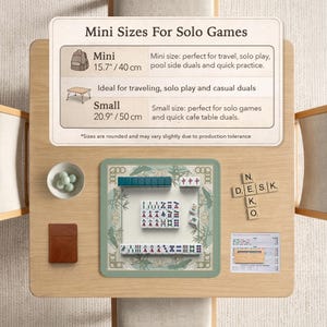 May include: A wooden table displays a mini Mahjong set with green tiles and a decorative border. The set includes a small brown notebook, a bowl of green stones, and a sign indicating mini and small sizes, 15.7" and 20.9" respectively.