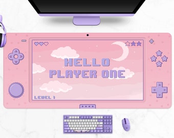 May include: Pink gaming mousepad with a controller design. The mousepad features the text "HELLO PLAYER ONE" in pixelated purple letters, along with pixel art clouds, stars, and a moon. A matching keyboard and mouse are also visible.