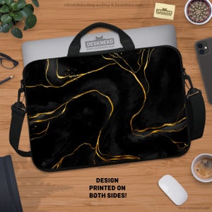 May include: Black laptop sleeve with a gold marble design. The sleeve has a black shoulder strap and a handle. The text "DESIGN PRINTED ON BOTH SIDES!" is printed on the bottom of the sleeve. The brand name "DESKNEKO" is visible.