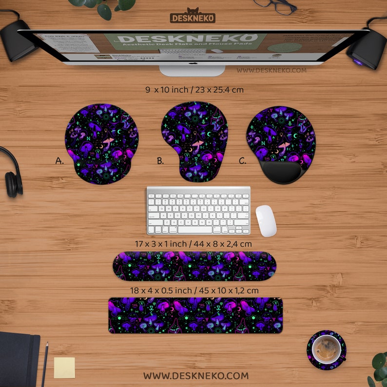 May include: A collection of desk accessories featuring a black background with a pattern of purple mushrooms, moons, and stars. Includes mouse pads, wrist rests, and a coaster. The mouse pads are 9 x 10 inches. The wrist rests are 17 x 3 x 1 inches and 18 x 4 x 0.5 inches.
