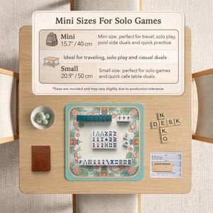 May include: A tabletop setup featuring a teal and white Mahjong set with tiles, a small brown notebook, and a bowl of green spheres. The text "Mini Sizes For Solo Games" is displayed above the set, with size details of 15.7 inches / 40 cm and 20.9 inches / 50 cm.